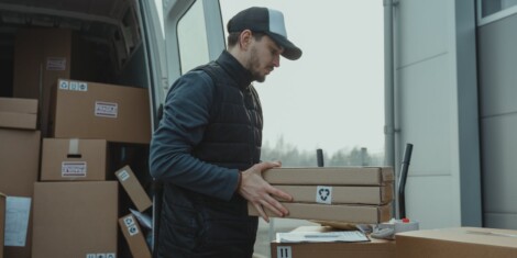Small parcel shipping delivery man checking the manifest during delivery