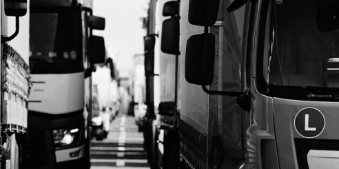 grayscale photo of EV trucks on road